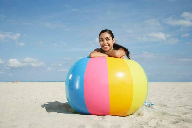 Teenage Girl Relaxing On Colorful Beach Ball - Happy teenage girl relaxing on large colorful ball on sandy beach model released Symbolfoto Copyright: xmoodboardx Panthermedia75408016.jpg