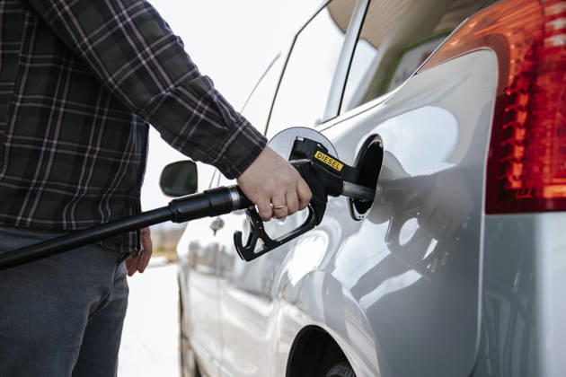 Hand holding diesel nozzle refilling car at gas station model released, Symbolfoto property released, HDF00286