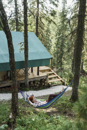 Serene camper resting in a hammock near Siberia glamping tent model released, Symbolfoto property released, VBUF00783