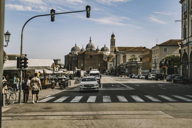 Padova, italy 1 october 2025: people crossing a busy padua street with cars and the historic basilica di sant antonio rising behind, sunny urban summer scene Padua city street life with historic basilica Copyright: xx 0835
