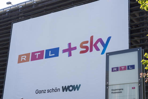 An der Einfahrt zu einem Parkhaus auf dem Gelände von RTL Deutschland hängt ein Plakat mit dem Slogan RTL+ Sky ganz schön WOW. Nach einer wettbewerbsrechtlichen Prüfung hat die EU-Kommission die Übernahme von Sky Deutschland durch die RTL Group genehmigt. RTL Medienunternehmen Firmensitz am Kölner Messeturm. Der Hauptsitz des TV-Sender RTL am Picassoplatz in Köln (Koeln) Deutz. RTL Logo. Copyright: MarcoxBader