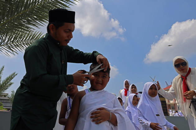 April 27, 2026, Banda Aceh, Aceh, Indonesia: Kindergarten children who are guided by their teachers, carry out simulation haircut (tahallul) during Hajj manasik education at the Aceh Hajj Embarkation Dormitory in Banda Aceh City, Aceh province, Indonesia on Monday, April 27, 2026. The activity which was attended by thousands of kindergarten students, aims to introduce the procedures for Hajj to children from an early age. Banda Aceh Indonesia - ZUMAs340 20260427_zip_s340_025 Copyright: xKhairuxSyukrillahx