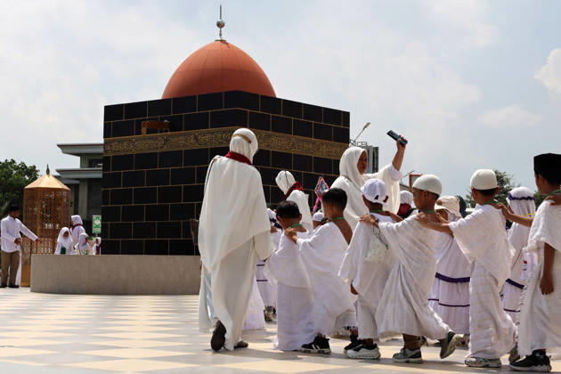 April 27, 2026, Banda Aceh, Aceh, Indonesia: Kindergarteners children performing tawaf around a miniature Kaaba companied by teacher during Hajj manasik education at the Aceh Hajj Embarkation Dormitory in Banda Aceh City, Aceh province, Indonesia on Monday, April 27, 2026. The activity which was attended by thousands of kindergarten students, aims to introduce the procedures for Hajj to children from an early age. Banda Aceh Indonesia - ZUMAs340 20260427_zip_s340_021 Copyright: xKhairuxSyukrillahx