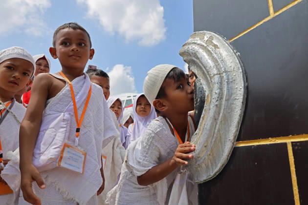 April 27, 2026, Banda Aceh, Aceh, Indonesia: Kindergarteners children Kissing the Hajar al-Aswad at the miniature Kaaba companied by teacher during Hajj manasik education at the Aceh Hajj Embarkation Dormitory in Banda Aceh City, Aceh province, Indonesia on Monday, April 27, 2026. The activity which was attended by thousands of kindergarten students, aims to introduce the procedures for Hajj to children from an early age. Banda Aceh Indonesia - ZUMAs340 20260427_zip_s340_012 Copyright: xKhairuxSyukrillahx