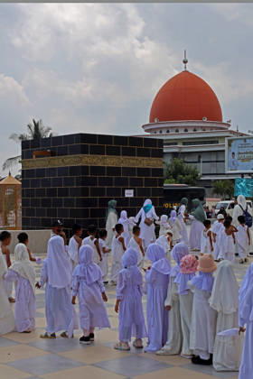 April 27, 2026, Banda Aceh, Aceh, Indonesia: Kindergarteners children performing tawaf around a miniature Kaaba companied by teacher during Hajj manasik education at the Aceh Hajj Embarkation Dormitory in Banda Aceh City, Aceh province, Indonesia on Monday, April 27, 2026. The activity which was attended by thousands of kindergarten students, aims to introduce the procedures for Hajj to children from an early age. Banda Aceh Indonesia - ZUMAs340 20260427_zip_s340_001 Copyright: xKhairuxSyukrillahx