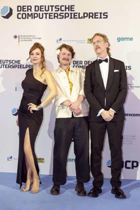 Katrin Bauerfeind, Gast und Uke Bosse bei der Verleihung des Deutschen Computerspielpreises 2026 im Herkulessaal der Residenz. München, 29.04.2026