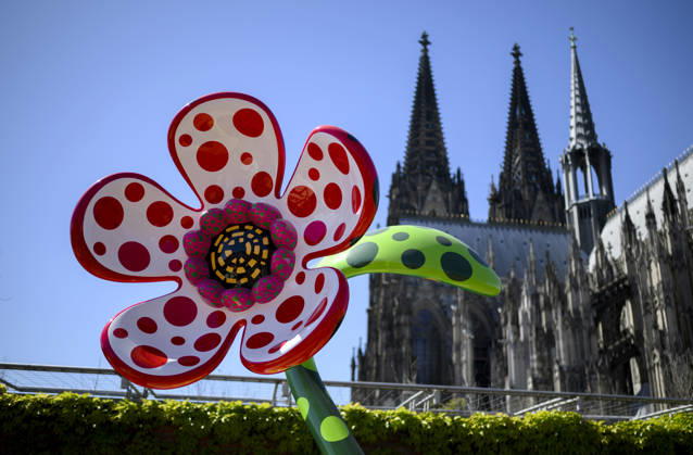 ! Achtung: Foto nur zur Nutzung im Rahmen der Berichterstattung über die Kusama-Ausstellung vom 14.3. - 2.8.2026 im Museum Ludwig in Köln ! Bunt bemalte Bronze-Blume - Flowers That Speak All about My Heart Given to the Sky - auf der Dachterrasse, im Hintergrund der Kölner Dom. Yayoi Kusama Ausstellung im Museum Ludwig in Köln Deutschland am 29.04.2026. Museum Ludwig
