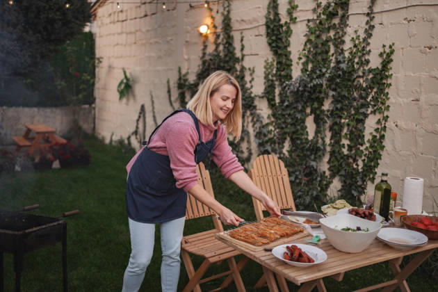 Ein fröhliches Sommertreffen mit Köstlichkeiten vom Grill und üppigem Grün Cook prepares a delicious spread outdoors amidst lush greenery and warm lights. (License=RF) ,model released, Symbolfoto Copyright: xZoonar.com JelenaxCvetkovicx 24972043 ,model released, Symbolfoto ,property released