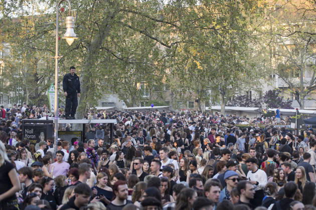 1. Mai, Impressionen aus Kreuzberg, Berlin, 01.05.2026 Ein Polizist steht auf einem Wartehäuschen und beobachtet den überfüllten Mariannenplatz nach einem Konzert der Rapperin Ikkimel auf dem Berliner Mariannenplatz am 01.05.2026. Berlin Mariannenplatz Copyright: xBenxKriemannx