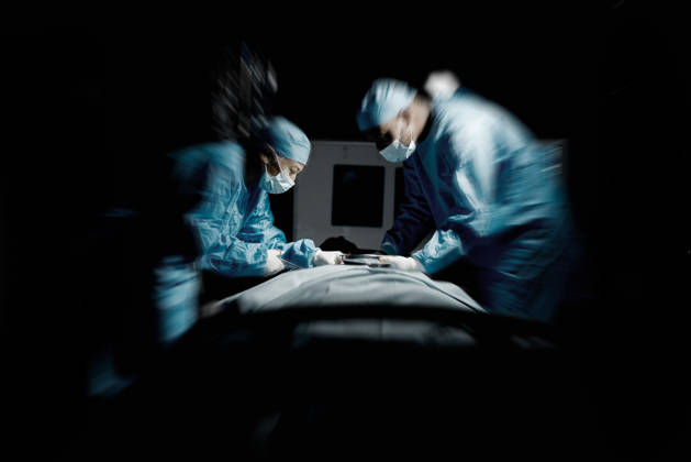 Doctors, night surgery and hospital theater with patient and surgeon team for emergency, teamwork and trust. Medical man and woman in dark for life saving, healthcare and health insurance emergency. (License=RF) ,model released, Symbolfoto  Copyright: xZoonar.com YurixArcursxpeopleimagesxcomx 19767778 ,model released, Symbolfoto ,property released