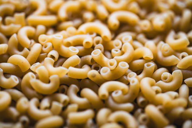 Close up of lots of dry uncooked macaroni pasta filling frame. Kingston, Ontario, Canada R_DOHO260502B-2010683-01