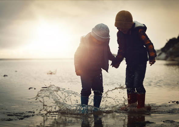 Beach, sunset and silhouette of children in water splash together, holding hands and playing in waves. Fun, holiday and brothers, happy in boots on ocean vacation, jumping in sea on winter evening (License=RF) ,model released, Symbolfoto  Copyright: xZoonar.com YurixArcursxpeopleimages.comx 20001147 ,model released, Symbolfoto ,property released
