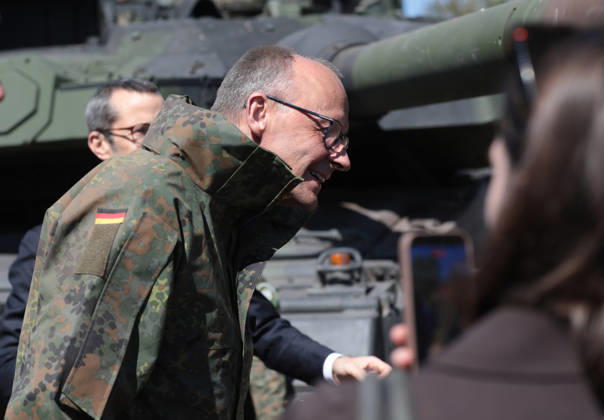 Bundeskanzler Friedrich Merz bei der Bundeswehr in Munster. Er senkt den Kopf vor einem Panzerrohr eines Leopard 2. Bundeskanzler Friedrich Merz bei der Bundeswehr in Munster. Er senkt den Kopf vor einem Panzerrohr eines Leopard 2. Munster Niedersachsen Deutschland