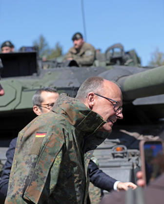 Bundeskanzler Friedrich Merz bei der Bundeswehr in Munster. Er senkt den Kopf vor einem Panzerrohr eines Leopard 2. Hochkant. Bundeskanzler Friedrich Merz bei der Bundeswehr in Munster. Er senkt den Kopf vor einem Panzerrohr eines Leopard 2. Munster Niedersachsen Deutschland