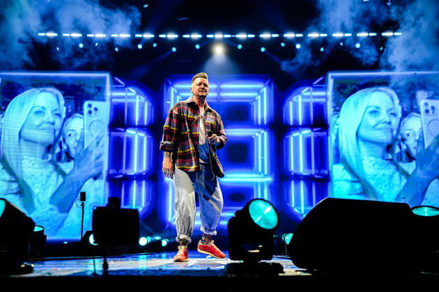Ben Zucker singt auf der Bühne vor einer illuminierten LED-Wand mit blauen Lichteffekten, im Hintergrund sind Projektionen von Konzertbesuchern mit Handykameras zu sehen. Köln, Lanxess Arena, 09.05.2026 NRW DE