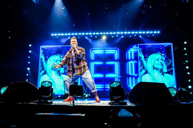 Ben Zucker performt auf der Bühne mit Mikrofon vor leuchtenden blauen LED-Bildschirmen während der Schlagernacht des Jahres in der LANXESS arena. Köln, 09.05.2026 NRW DE