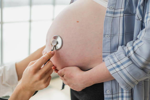 Arzt untersucht schwangere Frau hält Stethoskop in der Nähe von großen Bauch hören Baby Herzschlag. Gynäkologe Arzt Beratung Patientin über Schwangerschaft im Krankenhaus Büro. Besuch beim Arzt medizinischen Checkup. Doctor examining pregnant woman holding stethoscope near big belly listening baby heartbeat. Gynecologist doctor consulting patient about pregnancy in hospital office. Visit to doctor medical checkup (License=RF) ,model released, Symbolfoto Copyright: xZoonar.com IuliiaxZavalishinax 25046898 ,model released, Symbolfoto ,property released