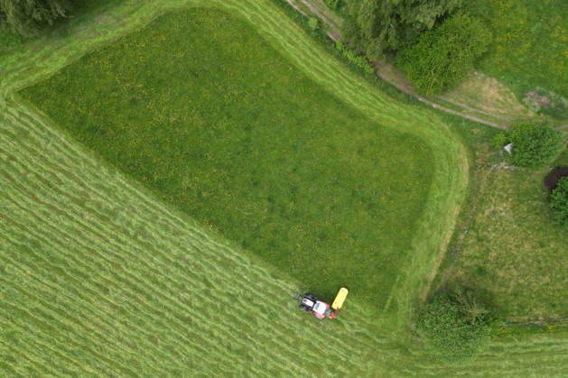 Luftaufnahme. Fruehling (Frühling) im Siegerland. Eine saftig gruene (grüne) Wiese wird von einem Traktor mit einem Maehwerk (Mähwerk) bei Siegen-Oberschelden gemaeht (gemäht). Fruehling (Frühling) im Siegerland am 23.05.2026 in Siegen Deutschland.