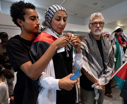 May 23, 2026, Montreal, Pq, CANADA: Safa Chebbi, left, and Ehab Lotayef, right, stand as Chebbi s son wraps her in a Palestinian flag as they arrive back at Montreal s Trudeau International Airport on Saturday, May 23, 2026. Chebbi and Lotayef were two of the 12 Canadians who were on board a flotilla trying to reach Gaza and spent four days in Israeli captivity. Montreal CANADA  - ZUMAc35_ 20260523_zaf_c35_156 Copyright: xPeterxMccabex