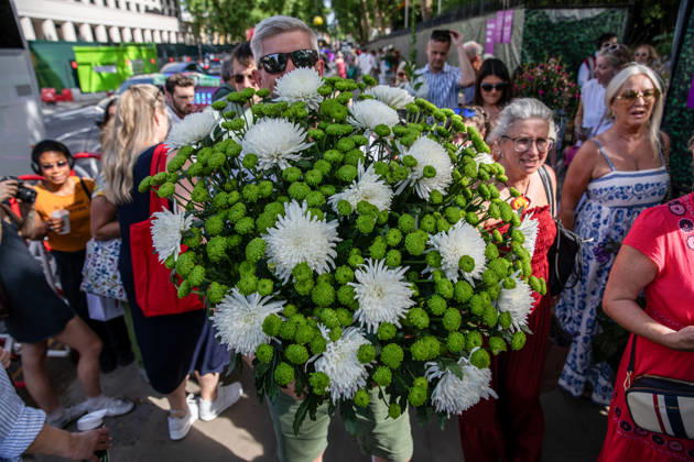 May 23, 2026, London, United Kingdom: A visitor to the last day of the RHS Chelsea Flower Show stands holding a large flower display. Members of the public leave the Chelsea Flower Show carrying flowers, plants, and garden ornaments purchased from the exhibition displays on the event™s final day. As the famous horticultural showcase drew to a close, visitors were seen transporting blooms, shrubs and decorative items through the streets of Chelsea after buying pieces from the award-winning gardens and floral exhibits. London United Kingdom - ZUMAs197 20260523_aaa_s197_505 Copyright: xJamesxWilloughbyx