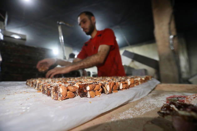 Palestinian workers produce traditional sweets ahead of Eid al-Adha Palestinian workers continued producing the traditional sweet known locally as Halakum at a factory in the Al-Daraj neighborhood, east of Gaza City, on May 24, 2026, ahead of Eid al-Adha. The factory resumed operations with limited resources after sustaining damage from Israeli airstrikes during the war. Halakum is a traditional sweet widely consumed during holidays, and the factory strives to provide it to residents despite the difficult living conditions and sharp decline in purchasing power in the Gaza Strip before Eid al-Adha. Photo by Bilal Osama apaimages Gaza city Gaza Strip Palestinian Territory 240526_Gaza_BO_01(32) Copyright: xapaimagesxBilalxOsamax xapaimagesx