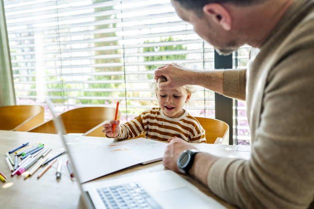 Remote working dad taking care of ill child during home office day. Father working from home while caring for sick toddler staying home from daycare. model released