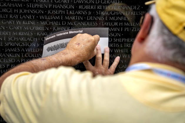 A volunteer etches a name onto paper at the Vietnam Veterans Memorial on Memorial Day in Washington, DC on Monday, May 25, 2026.  WAP20260525306 BONNIExCASH