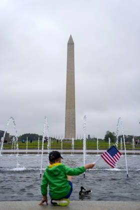 A child waves a U.S. Flag at the World War II Memorial on Memorial Day in Washington, DC on Monday, May 25, 2026.  WAP20260525321 BONNIExCASH