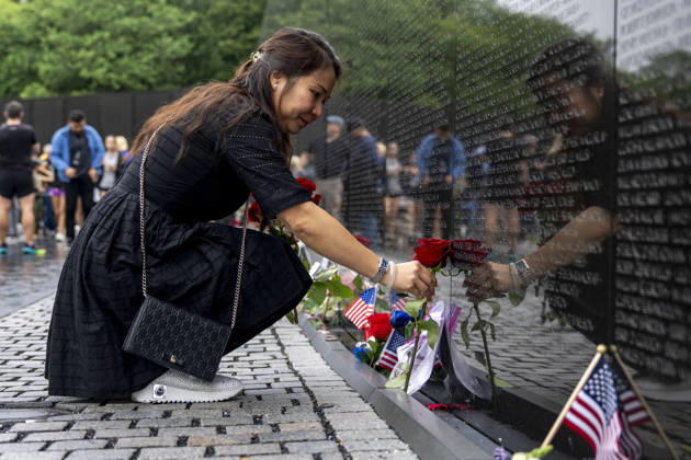 A woman leaves roses at the Vietnam Veterans Memorial on Memorial Day in Washington, DC on Monday, May 25, 2026.  WAP20260525323 BONNIExCASH