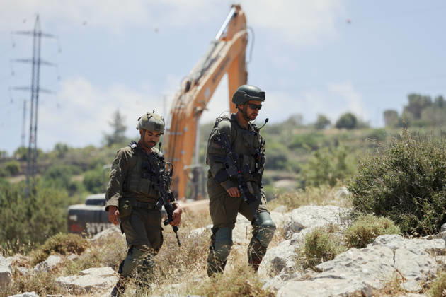Israeli Demolition West Bank Family Displaced Eid Al-Adha Armed Israeli soldiers walk near a demolition excavator in Nahhalin, occupied West Bank, on May 25, 2026, after an operation. The demolition, carried out by Israeli forces who stated the structure was built without a permit, displaced an eight-member Palestinian family just two days before the Islamic holiday of Eid al-Adha. Bethlehem West Bank Palestinian Territories Copyright: xMosabxShawerx