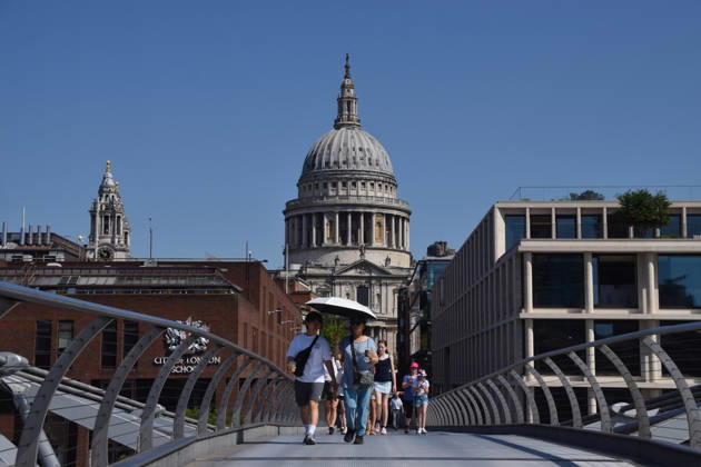 May 26, 2026, London, England, United Kingdom: People shelter from the scorching sun under an umbrella on Millennium Bridge with a view of St Paul s Cathedral as temperatures soar in the capital. The UK recorded its hottest ever day in May yesterday. London United Kingdom - ZUMAv130 20260526_zip_v130_001 Copyright: xVukxValcicx