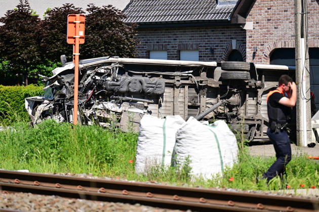 (260526) -- BUGGENHOUT, May 26, 2026 -- A man walks past the scene of a school bus and train collision accident in Buggenhout, East Flanders, Belgium, May 26, 2026. Four people were killed on Tuesday morning after a school bus rammed into a train at a crossing in the city of Buggenhout, the East Flanders province of Belgium, local media reported. ( Handout via Xinhua) (SpotNews) BELGIUM-BUGGENHOUT-SCHOOL BUS COLLISION DIRKxWAEM BELGAxPHOTO 