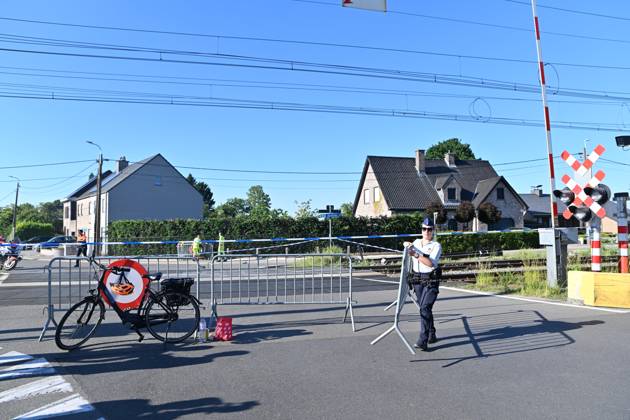 A police officer removes a barrier to clear the way for traffic on the scene of an accident between a train and a minivan, at the railway crossing Vierhuizen, in Buggenhout, Tuesday 26 May 2026. The accident happened around 8:15 am. Four people have been killed, the driver, two children and their supervisor. According to initial reports, the level crossing was closed at the time of the accident.  EMILExWINDAL 175109381