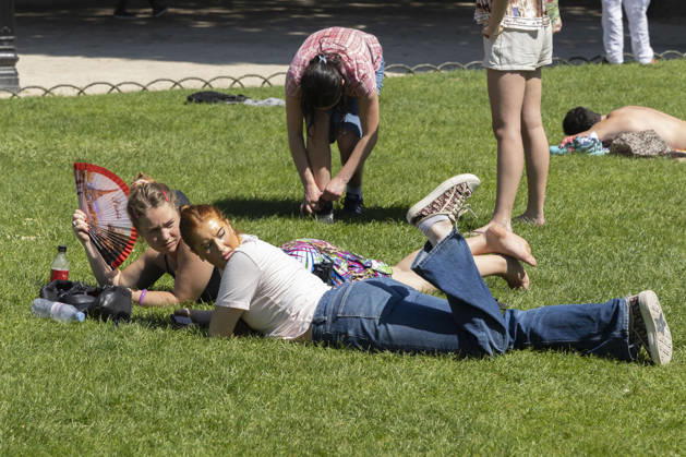 Paris, France May 27, 2026 - A person lays on the grass at Place des Vosges cools off with a fan during the heat wave .Temperatures in the French capital are about 10 degrees higher than the seasonal average, with temperatures exceeding 30 degrees, reaching the threshold for a heat wave. METEO, CANICULE, FORTES CHALEURS, ILLUSTRATION, ESTIVAL, ESTIVALE, GENERIQUE, SOLEIL, TOURISME, SITE TOURISTIQUE, PARIS, VIGILANCE, VAGUE DE CHALEUR, CHANGEMENT CLIMATIQUE, PLACE DES VOSGES, JARDIN, PARC, Copyright: xVincentxIsorex