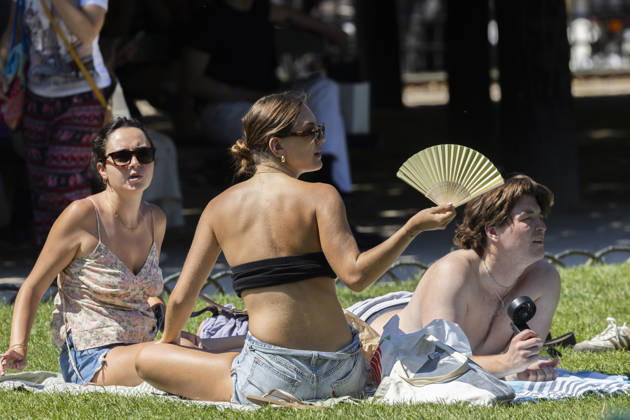 Paris, France May 27, 2026 - A person lays on the grass at Place des Vosges cools off with a fan during the heat wave .Temperatures in the French capital are about 10 degrees higher than the seasonal average, with temperatures exceeding 30 degrees, reaching the threshold for a heat wave. METEO, CANICULE, FORTES CHALEURS, ILLUSTRATION, ESTIVAL, ESTIVALE, GENERIQUE, SOLEIL, TOURISME, SITE TOURISTIQUE, PARIS, VIGILANCE, VAGUE DE CHALEUR, CHANGEMENT CLIMATIQUE, PLACE DES VOSGES, JARDIN, PARC, Copyright: xVincentxIsorex