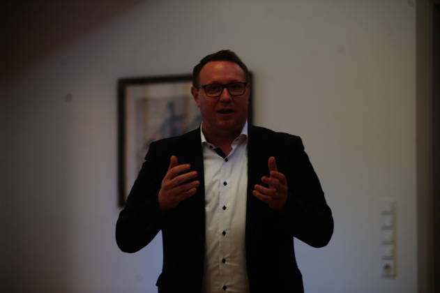 Flensburg, Schleswig-Holstein Vortrag & Diskussion mit Klaus Scherer ehem. ARD-Korrespondent in Washington, Journalist und Autor. Anlässlich des Besuchs der Amerika-Gesellschaft in Flensburg luden der SOF und SSW zu einem Abend mit Klaus Scherer ein. Thema: Die USA im politischen Hurrikan Ein aktueller Bericht über Entwicklungen, Lage und Perspektiven in den USA. Hier: es spricht Christian Dirschauer, Politiker (SSW,) er ist Mitglied des Landtag von Schleswig-Holstein. Aufnahme vom 27.05.2026, Flensburg.