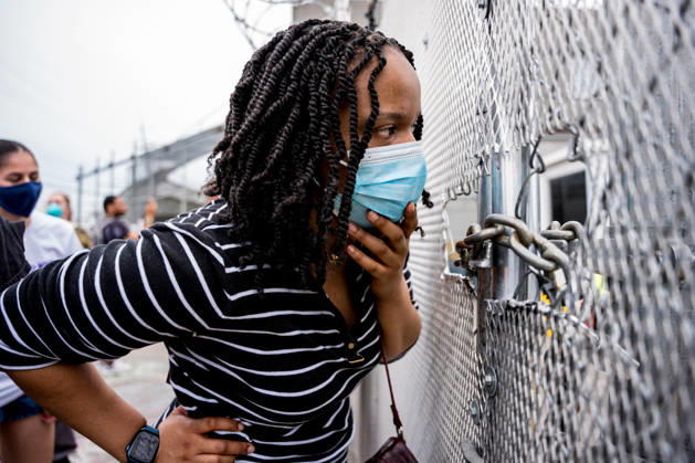 A volunteer peers inside the fence at Delaney Hall Detention Center in Newark, N.J. on Wednesday, May 27, 2026. Detainees have started a hunger strike to protest what they call inhumane conditions inside the ICE detention center.  NYP202605279012 ANGELINAxKATSANIS