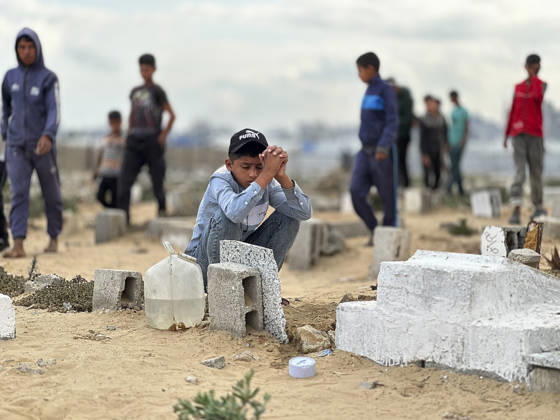 Eid Al Adha Cemetery Memorial Khan Yunis A boy sits with clasped hands next to a grave to offer prayers during Eid al-Adha at a cemetery in Khan Yunis, Gaza Strip, on May 27, 2026. Eid al-Adha, or the Feast of Sacrifice, is one of the most important holidays in the Islamic calendar, commemorating the willingness of Prophet Ibrahim to sacrifice his son. The event is traditionally marked worldwide by communal prayers, family gatherings, acts of charity, and the slaughtering of livestock. In Gaza, the ongoing conflict has significantly impacted traditional observances, leading to residents substituting fresh livestock with frozen meat and visiting the graves of those killed during the war. Khan Yunis Gaza Strip Palestinian Territories Copyright: xDoaaxAlbazx