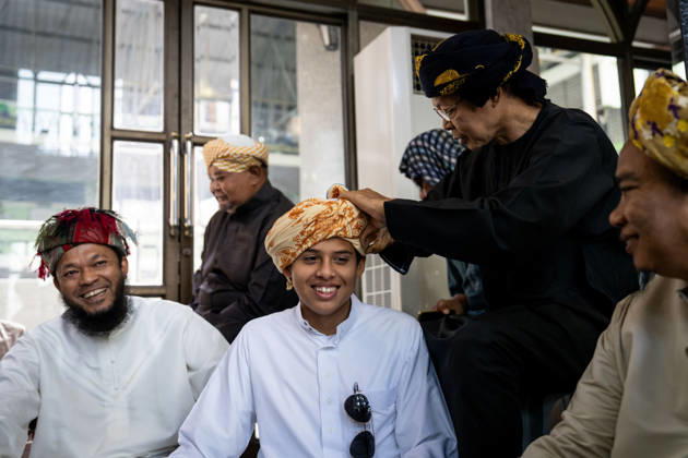 Eid al-Adha in Thailand BANGKOK, THAILAND - MAY 28: Community members help a young man tie his keffiyeh before praying. Thai Muslims pray during Eid al-Adha at Masjid Buddarul Mumineen mosque in Bangkok, Thailand on May 28, 2026. Matt Hunt Anadolu Bangkok Thailand. Editorial use only. Please get in touch for any other usage.  Copyright: x2026xAnadoluxMattxHuntx