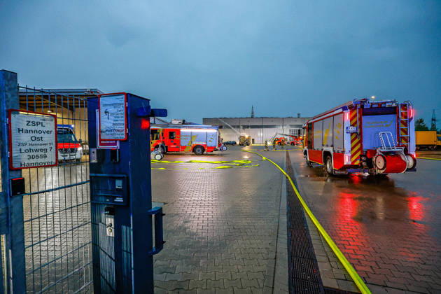 Großbrand in einer Lager- und Logistikhalle Haupteinfahr zur Lagerhalle, Löschfahrzeuge und Drehleiter der Feuerwehr Hannover im Hintergrund Hannover-Anderten Lohweg 7, Gewerbegebiet Niedersachsen, Region Hannover Germany