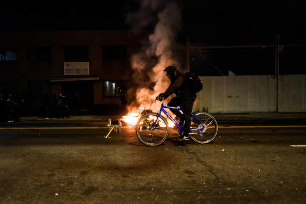 June 1, 2026, Newark, New Jersey, United States: A protester rides a bike past a fire set by protesters outside Delaney Hall during a protest. Protests continue to be held daily as detainees at Delaney Hall maintain a hunger and labor strike against current conditions at the facility. Newark United States - ZUMAs197 20260601_aaa_s197_241 Copyright: xMatthewxHatcherx