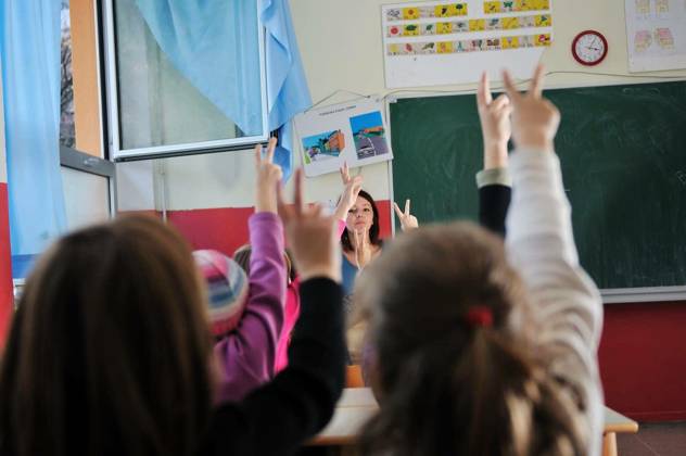 happy young teacher woman at elementrary school teaching and giving leassons to group of young smart children model released Symbolfoto Copyright: xdotshockx Panthermedia68608648