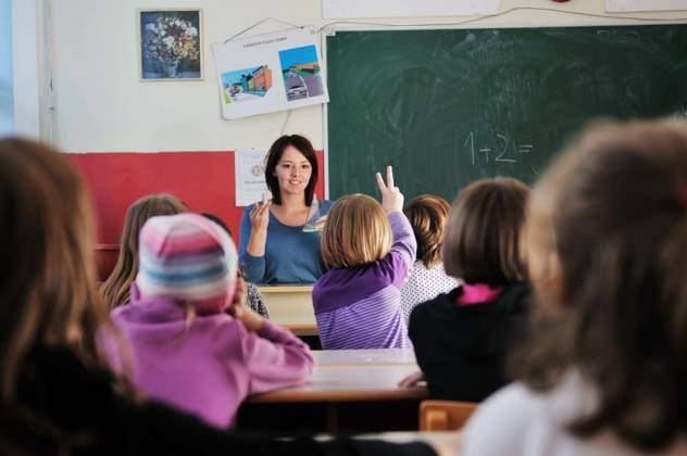happy young teacher woman at elementrary school teaching and giving leassons to group of young smart children model released Symbolfoto Copyright: xdotshockx Panthermedia68608654