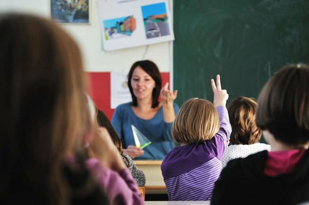 happy young teacher woman at elementrary school teaching and giving leassons to group of young smart children model released Symbolfoto Copyright: xdotshockx Panthermedia68608686