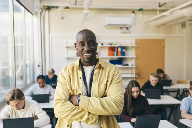 Portrait of smiling teacher standing with arms crossed in classroom at junior high school Sweden, Stockholm, model released, property released Copyright: xMaskotx , MA125461 MA125461