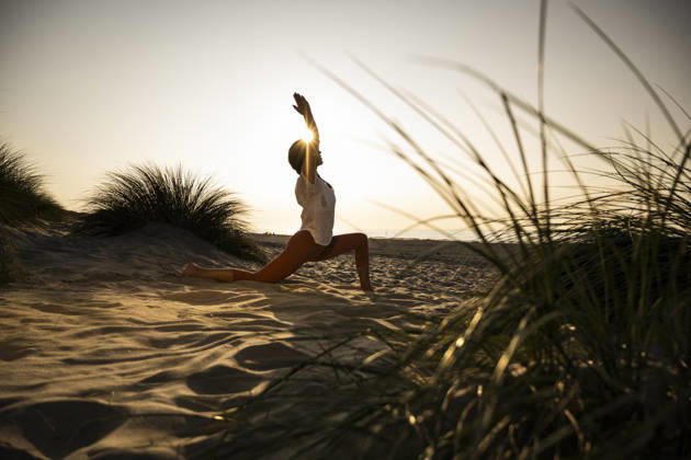 Woman practicing yoga on a sandy beach at sunset model released, Symbolfoto, UUF36838
