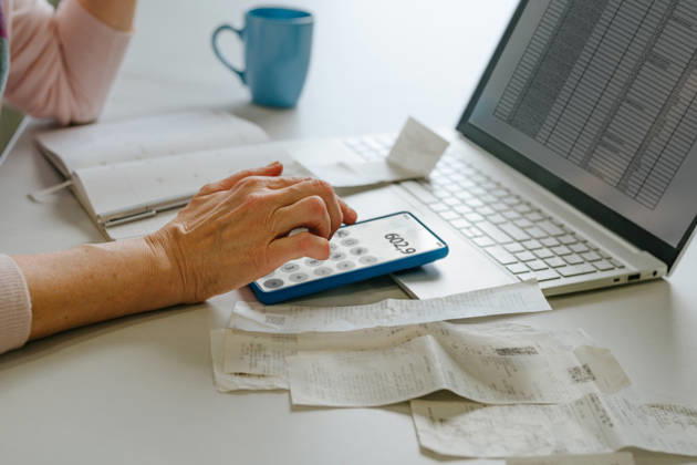 Woman calculating home budget and taxes using smartphone and laptop model released, Symbolfoto property released, YTF04874