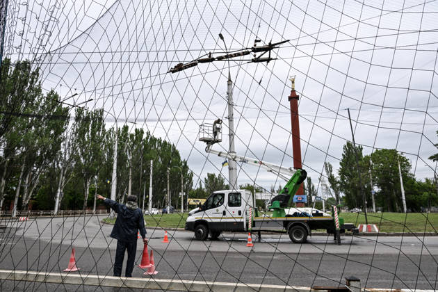 RECORD DATE NOT STATED Municipal workers install anti-drone netting to protect against Russian FPV drones in the yellow zone of the frontline city of Kherson, Ukraine, on June 3, 2026. The Russian army attacks the city daily with FPV drones and other unmanned aerial vehicles, deliberately terrorizing civilians. Russian forces conduct hunts for local residents, tracking them with FPV drones and dropping explosives. Police officers, medics, public transport, and urban infrastructure are also targeted. Based on the intensity of attacks, Kherson is informally divided into yellow and red zones, with the red zone considered the most dangerous due to constant shelling and drone strikes (Photo by Dmytro Smolienko Ukrinform) Life under shelling in frontline Kher Copyright: xDmytroxSmolienkox