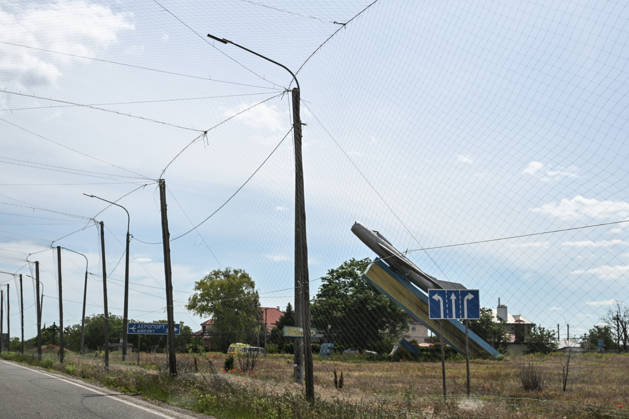 RECORD DATE NOT STATED The MiG-19 memorial commemorating the 40th anniversary of Victory stands at the entrance to Kherson International Airport in Chornobaivka, Kherson region, Ukraine, on June 2, 2026. The road leading to the airport is protected by anti-drone netting. The Russian army attacks Kherson and the surrounding region daily with FPV drones and other unmanned aerial vehicles, deliberately terrorizing civilians. Russian forces track residents using FPV drones and _drop_ explosives on them. Police officers, medics, public transport, and civilian infrastructure are also frequently targeted (Photo by Dmytro Smolienko Ukrinform) Life under shelling in frontline Kherson  Copyright: xDmytroxSmolienkox