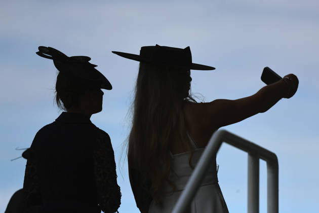 16.06.2026, Ascot, Windsor, GBR - Fashion, women with hats at the racecourse silhouetted against the sky. Ascot racecourse. (Zuschauer, Besucher, Publikum, Frauen, Huete, Kopfbedeckungen, Fashion, Eleganz, elegant, Mode, modisch, feminin, Rueckansicht, Silhouette, Schattenriss, Umriss, Gegenlicht, Gegenlichtaufnahme) 260616D503ROYAL_ASCOT